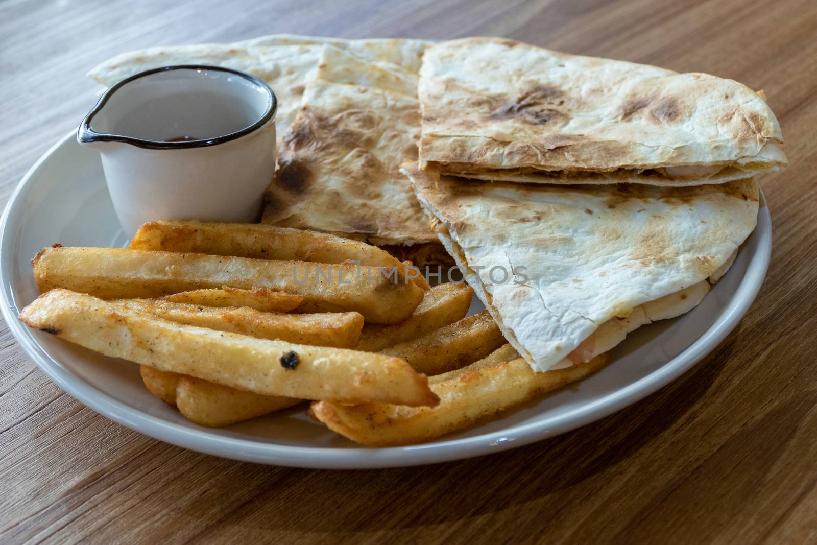 Quesadilla and french fries on plate