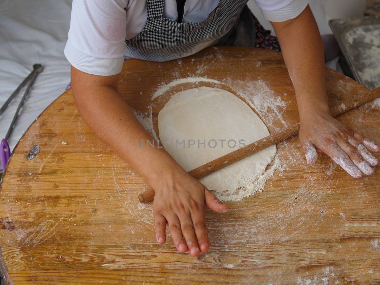 woman who makes "bazlama" and "yufka". raw dough opens with rolling pin