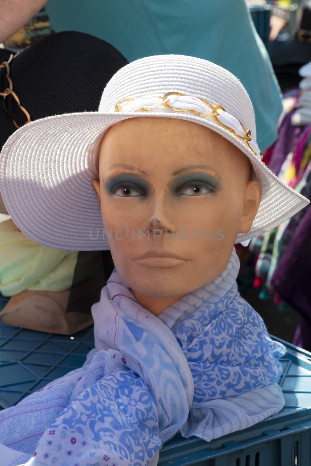 Woman mannequin with hat and scarf at open market retail display