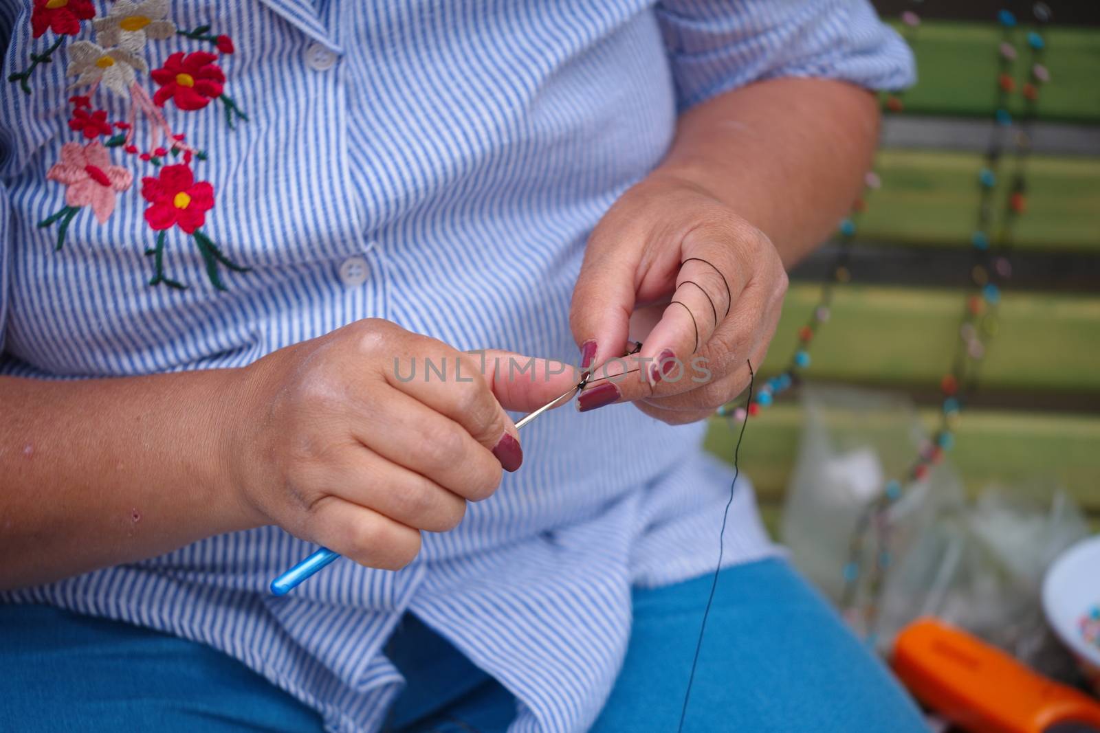 a woman stitch a child's clothe. hand work, lace weave.