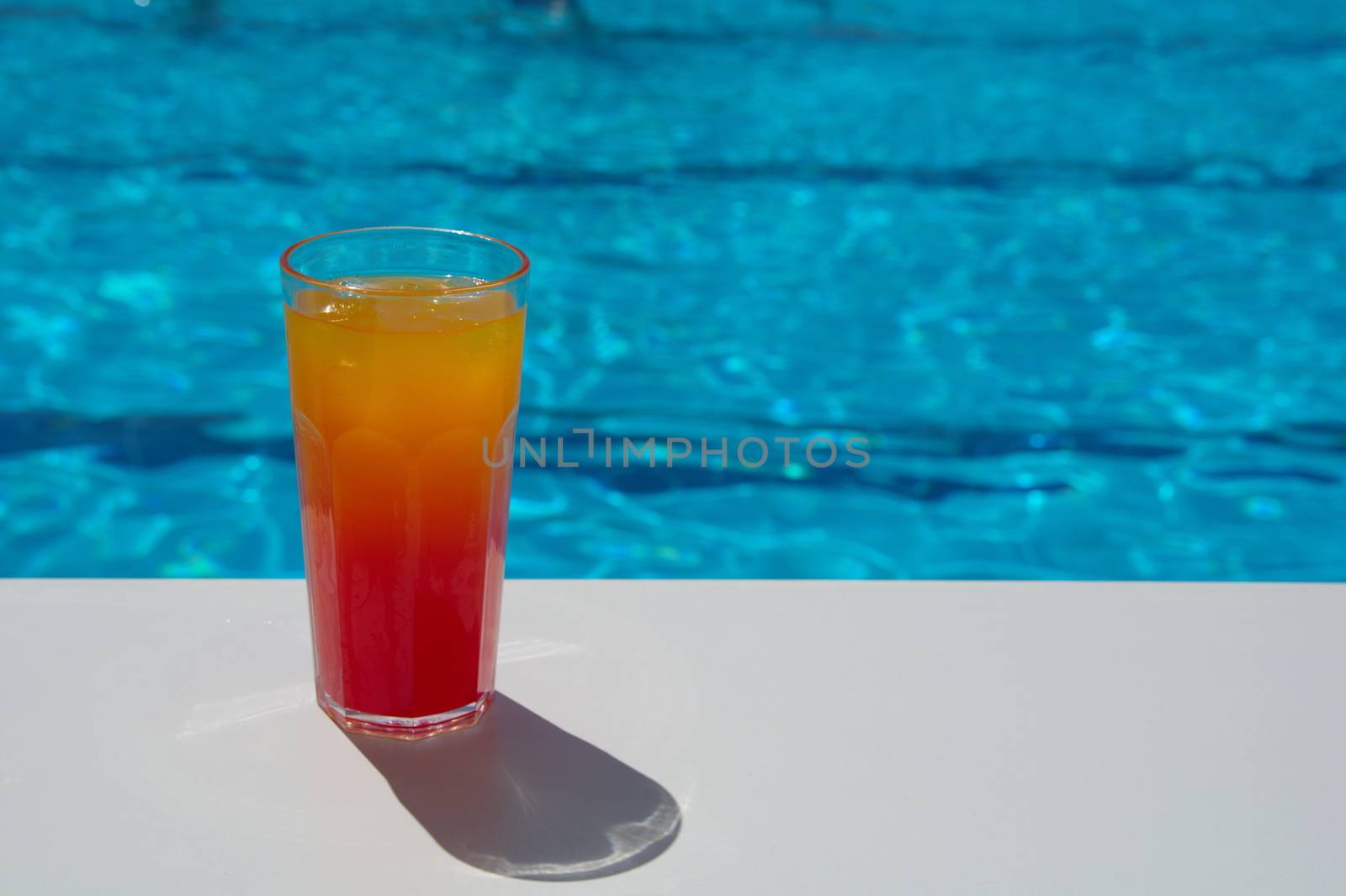 enjoying fresh lemon and mint tequila sunset cocktail by the pool