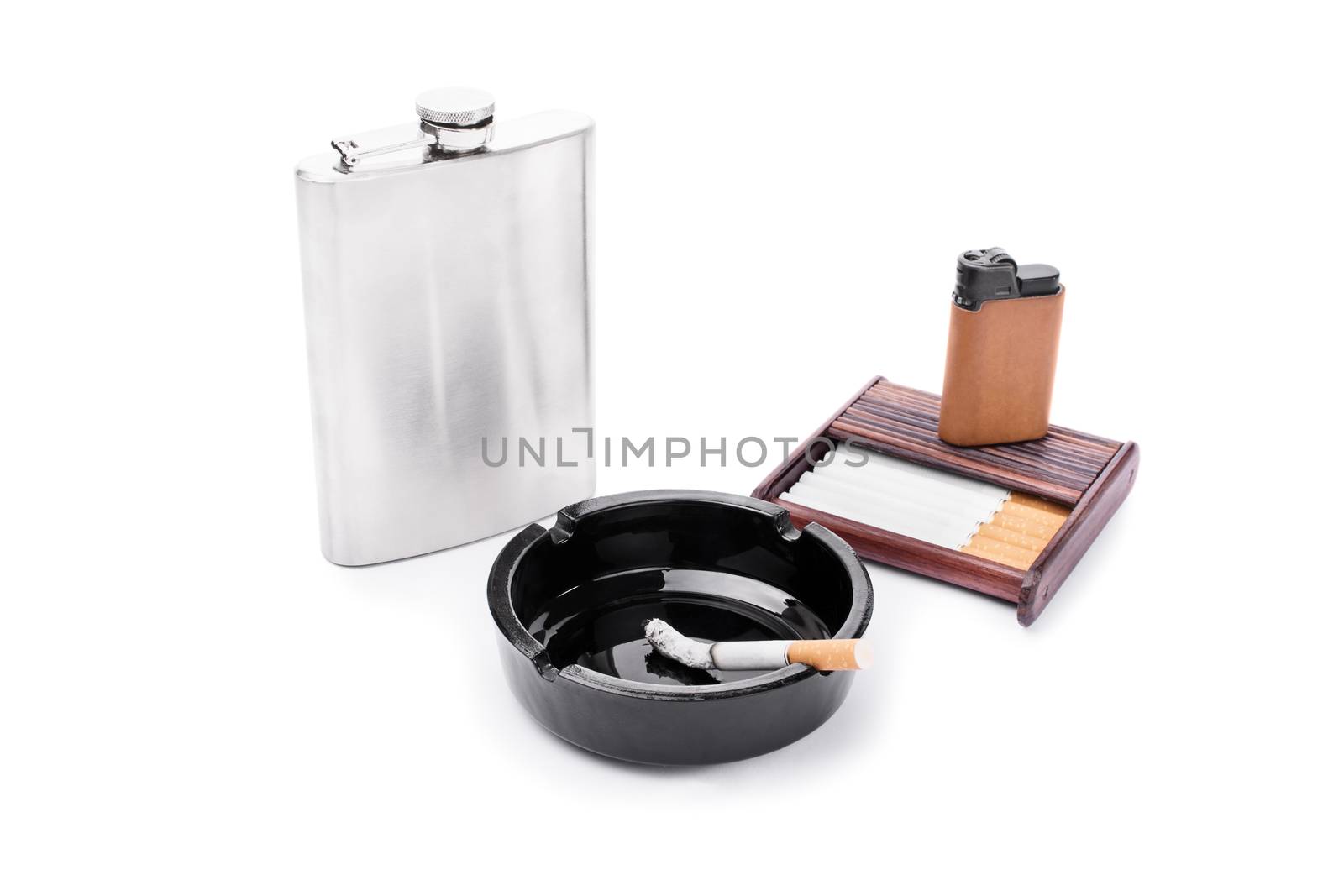 Stainless steel flask, ashtray, some cigarettes, and lighter on a cigarette case, isolated on white background.