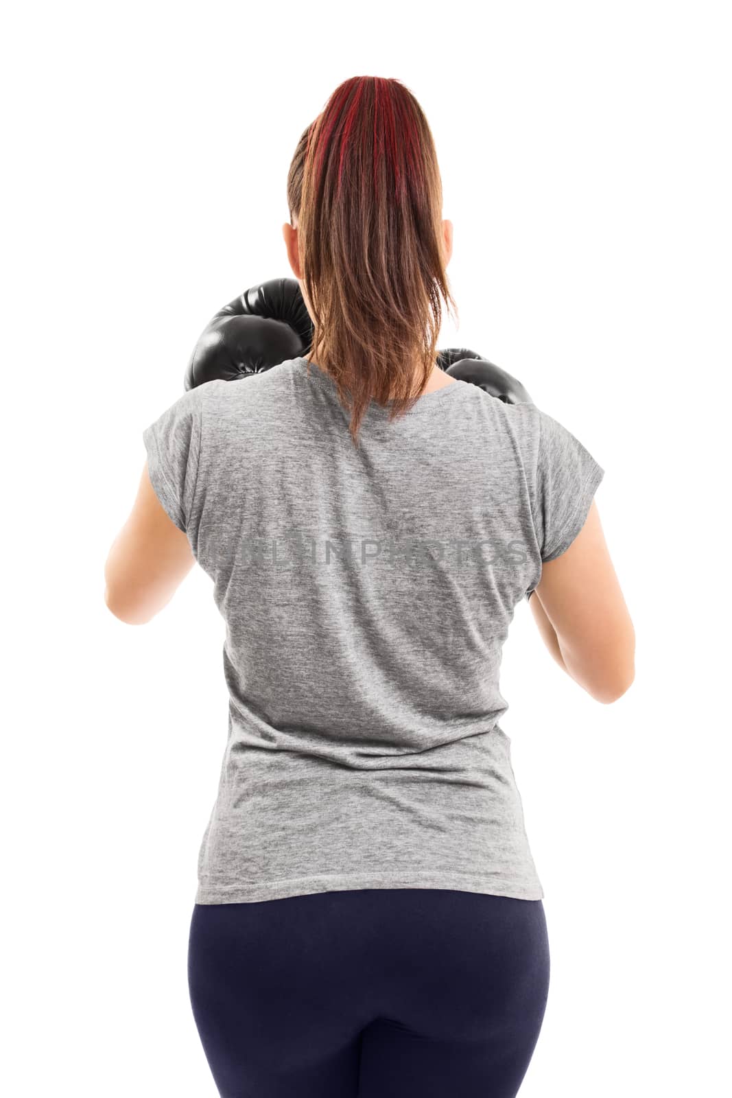 Muscular female boxer with her guard up, photographed from behind, isolated on a white background.