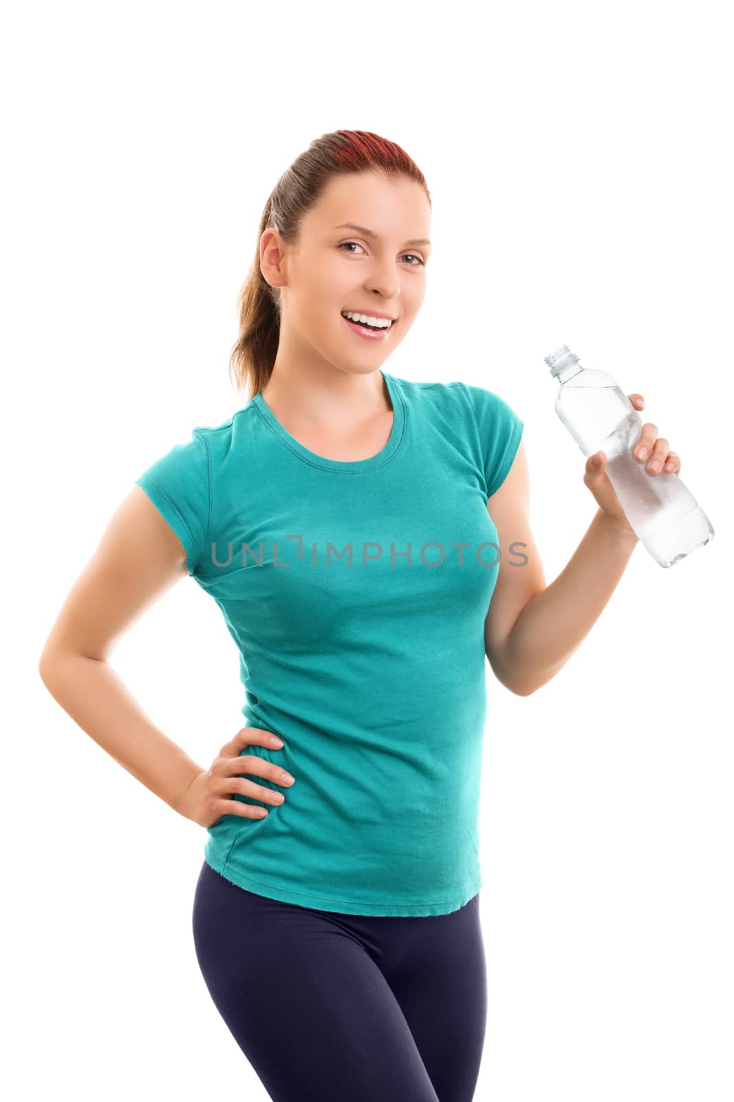 A portrait of a beautiful smiling young girl in fitness clothes holding a water bottle, isolated on white background.