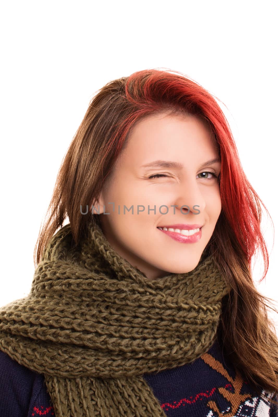 A portrait of a beautiful young girl in winter clothes, winking, isolated on white background.