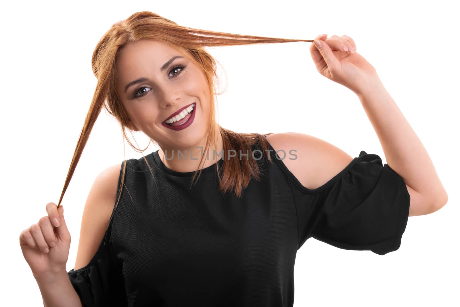A portrait of a beautiful smiling young girl playing with her hair, isolated on white background.