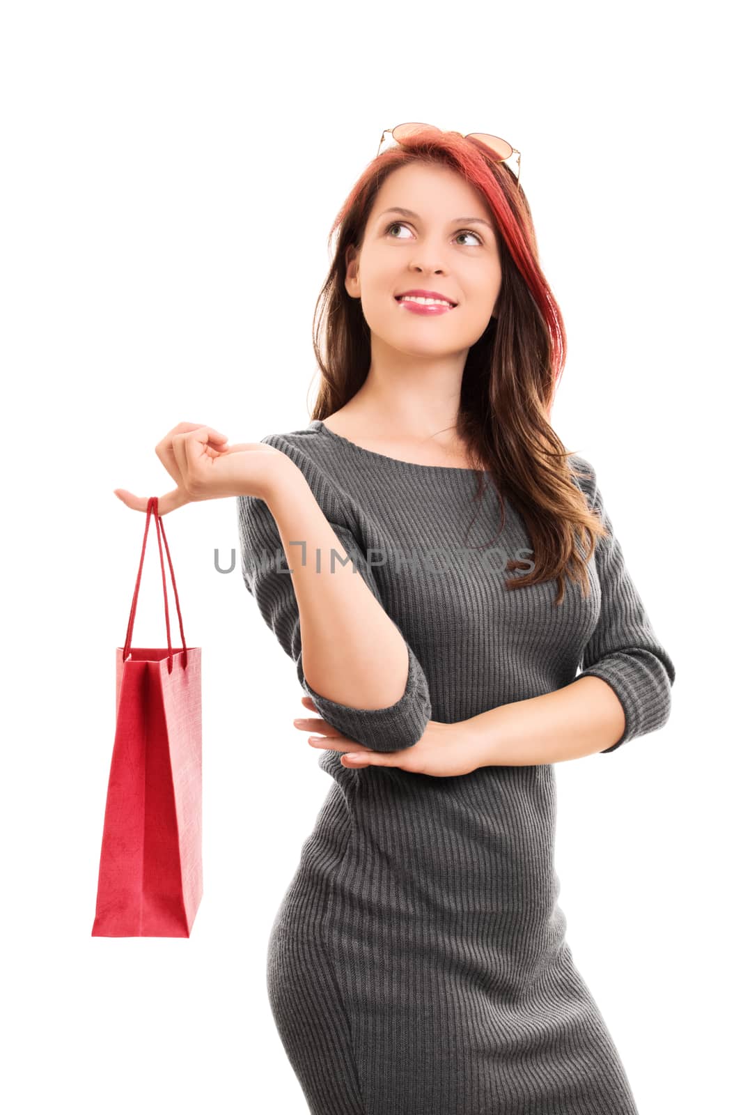 A portrait shot of a beautiful young girl in a dress, holding a shopping bag, isolated on white background.