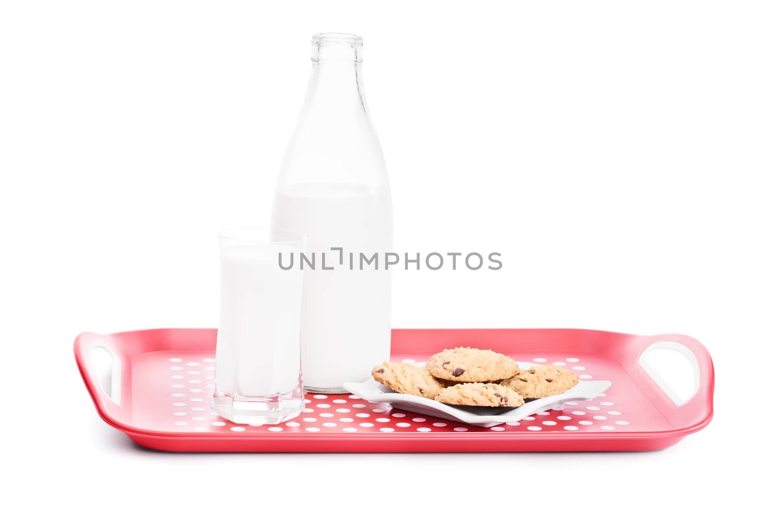 Close up shot of a bottle and glass of milk and chocolate chip cookies on a platter, isolated on white background.