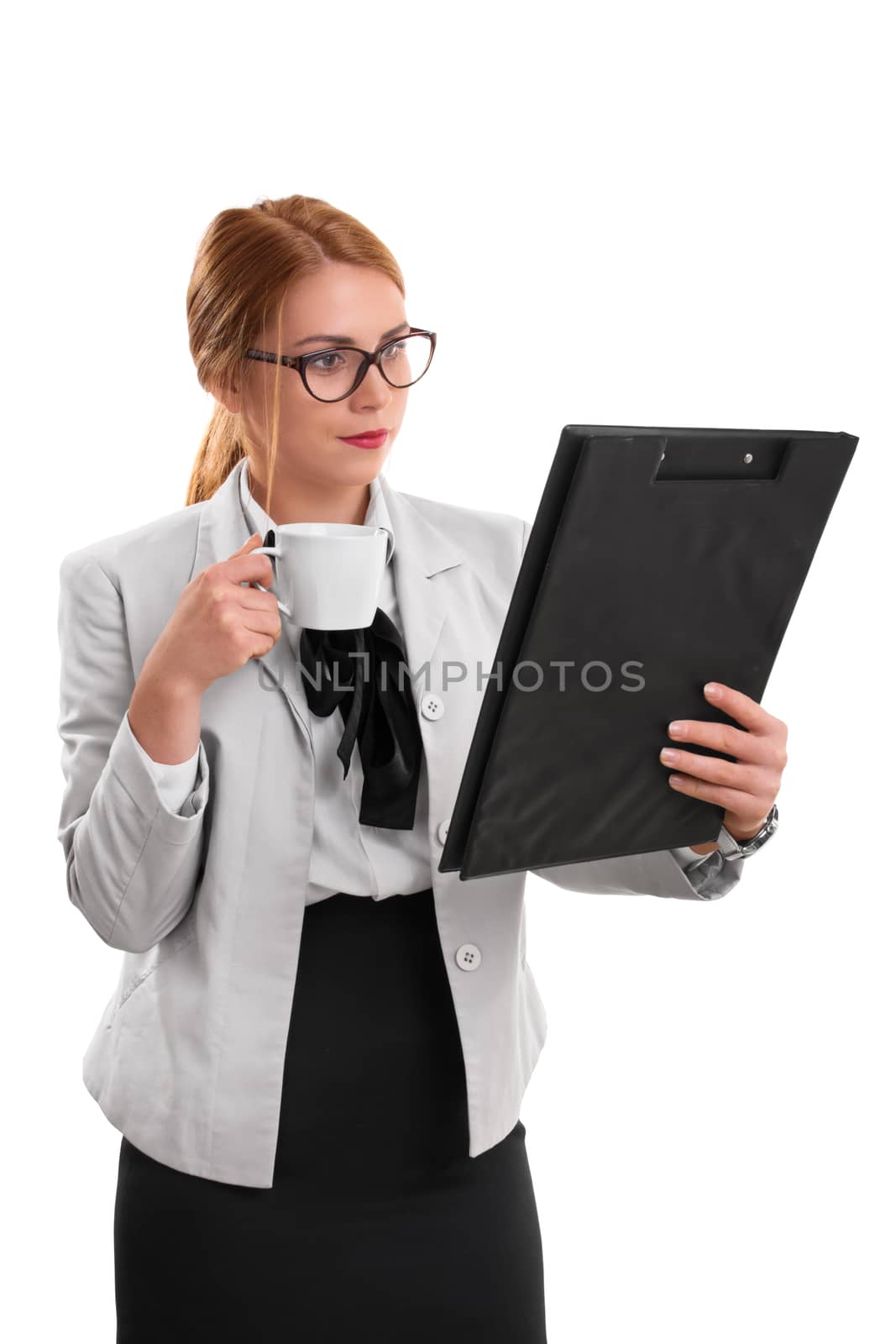 Morning meeting preparation. A portrait of a businesswoman, holding a cup of coffee and a clipboard, isolated on white background.