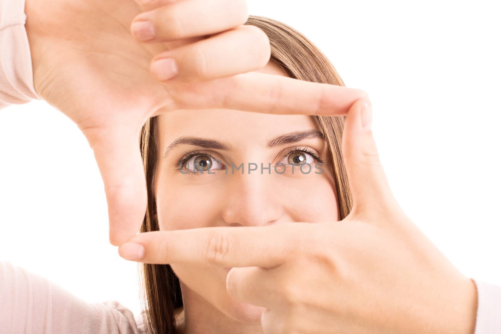 Beautiful girl looking through finger frame, isolated on white background.