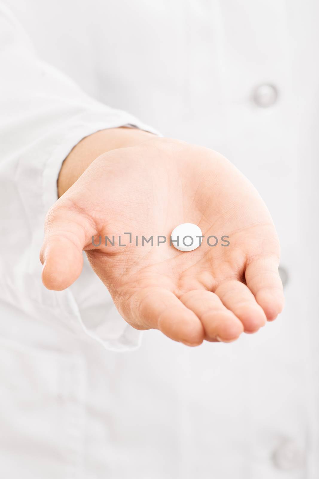 Have this and get better. Doctor's hand handing out a pill.