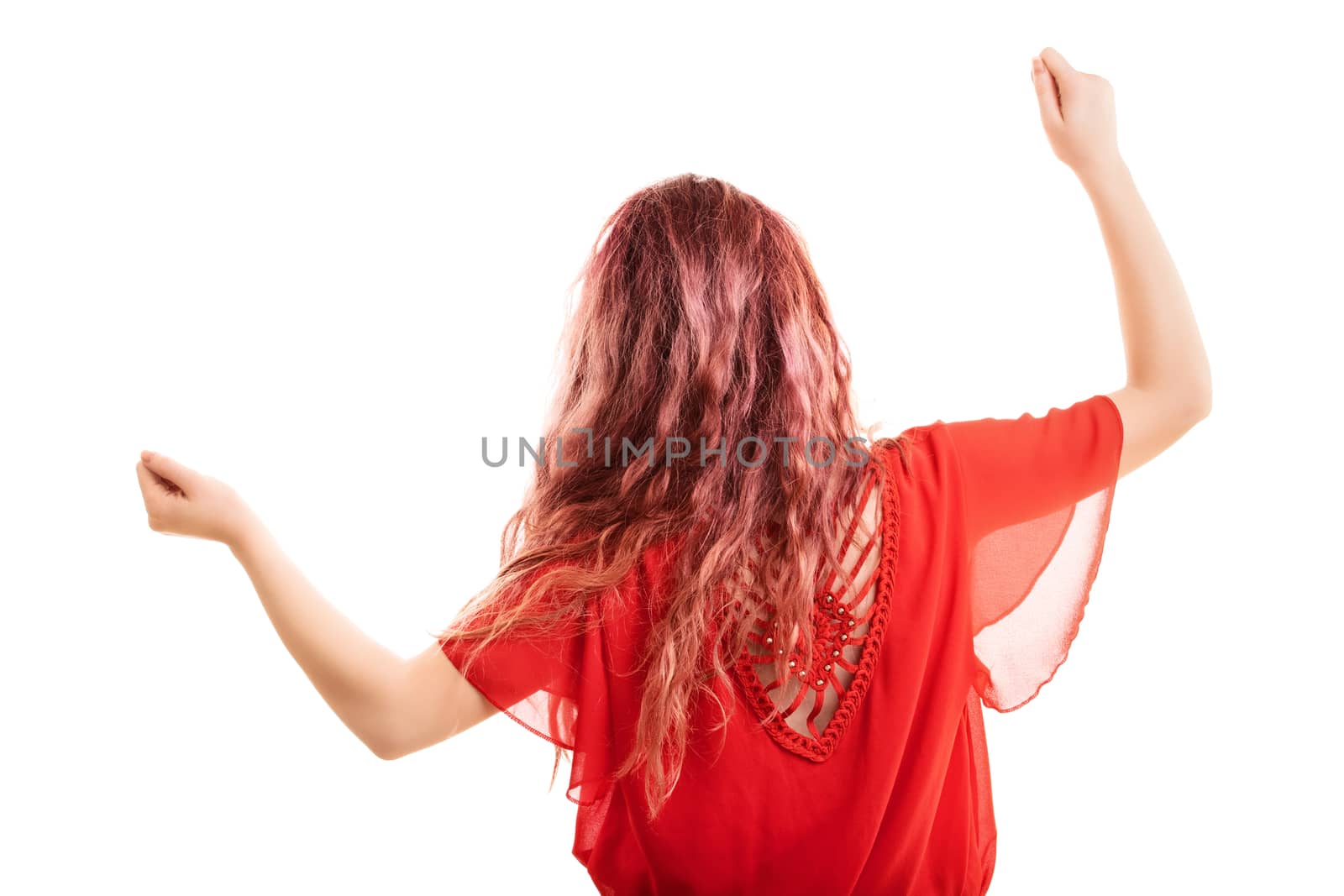 Redheaded girl turned with her back, dancing, gesturing with arms up, isolated on a white background