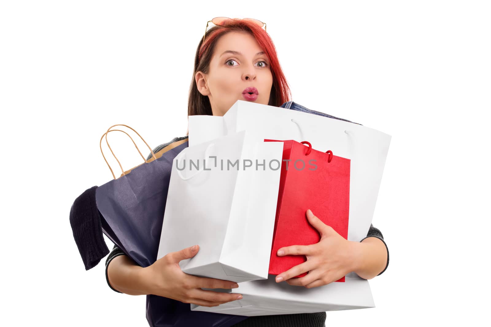 A portrait of an excited beautiful young girl holding a lot of shopping bags, isolated on white background.
