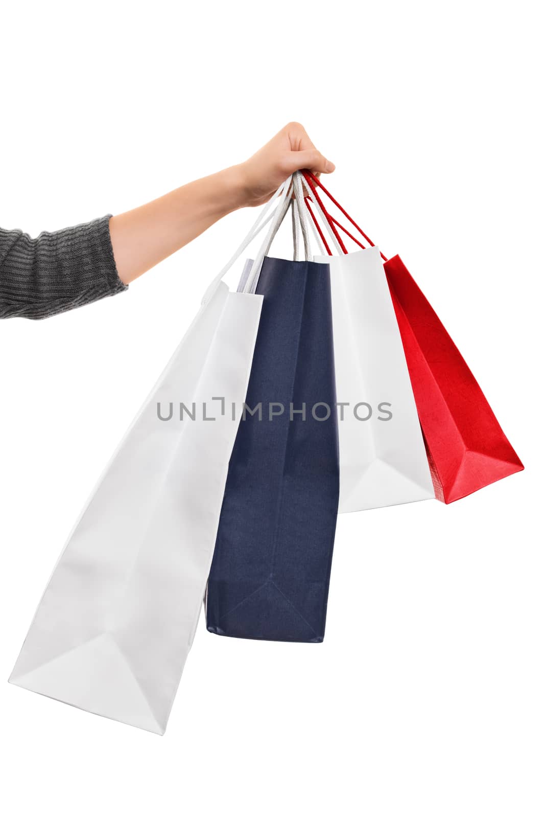 Female hand holding shopping bags isolated on white background by Mendelex