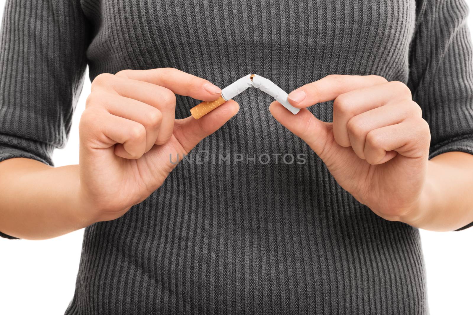 Break/Quit this bad habit. Young woman breaking a cigarette, isolated on a white background.