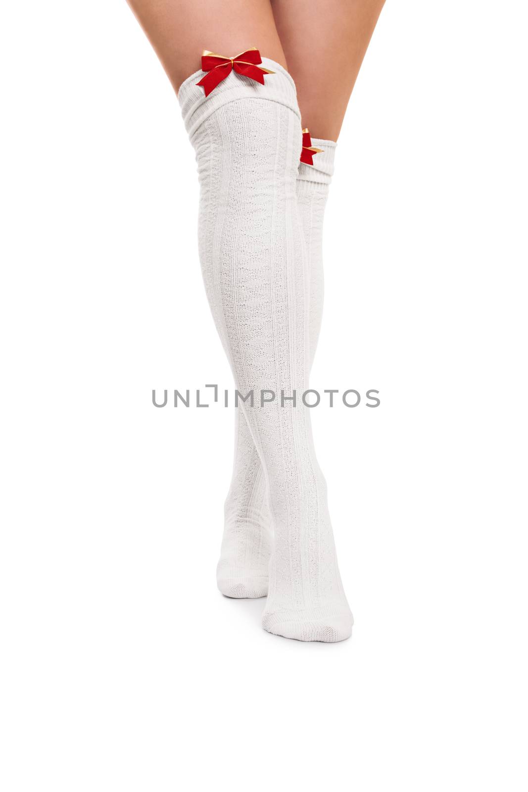 Female legs in white stockings with red bow ties, isolated on white background.