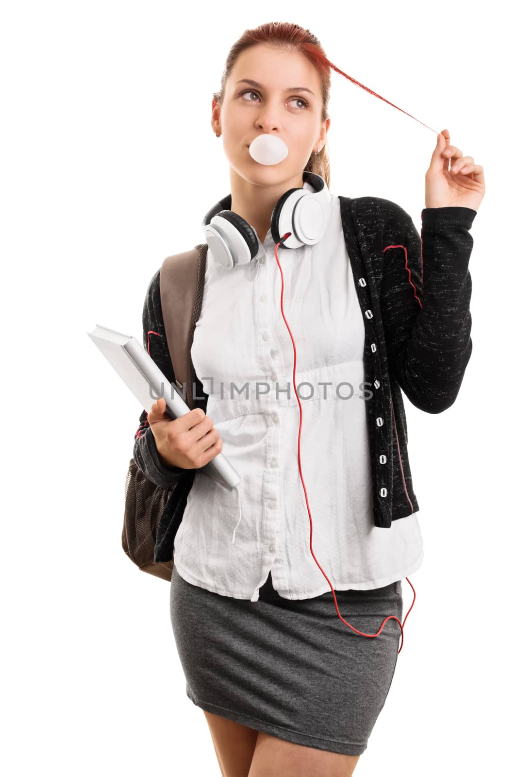 High school lifestyle. Young girl with books and backpack making bubble gum bubbles, playing with her hair, isolated on white background. Most popular girl in school.