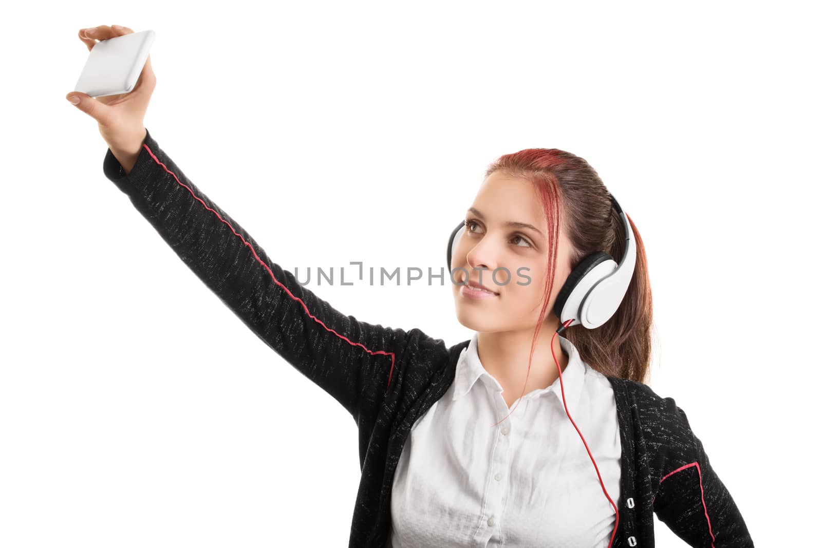 Young girl wearing headphones in a school uniform taking a selfie, isolated on white background.