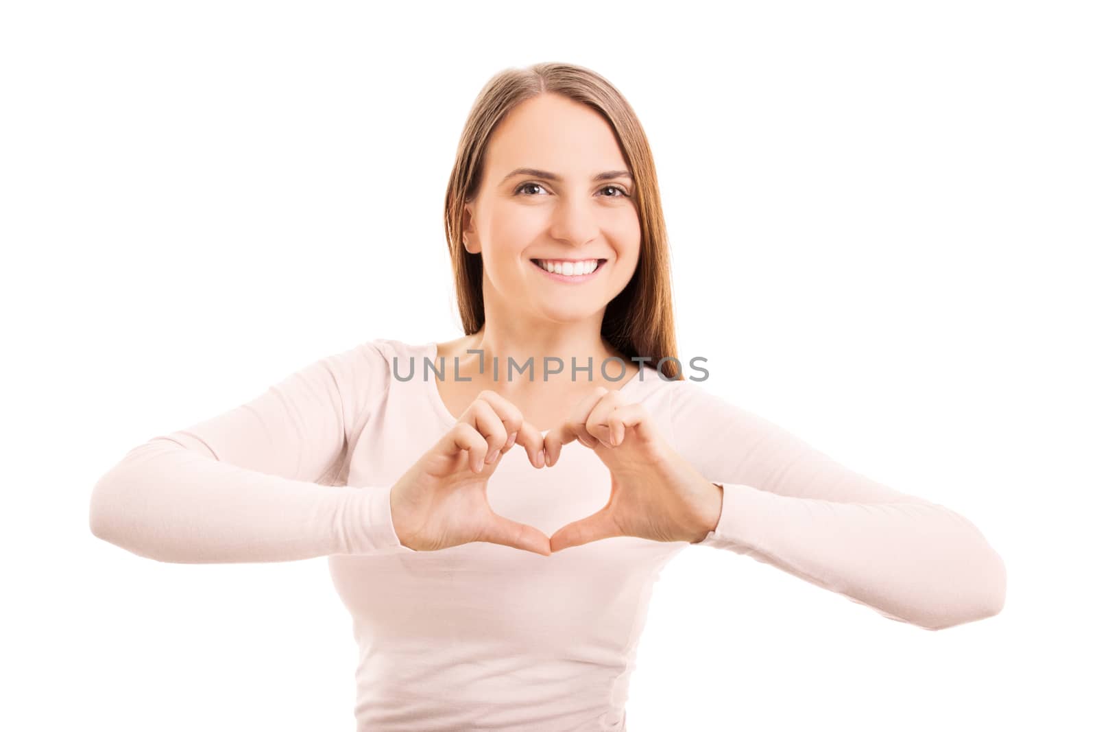 Beauty portrait of a smiling young girl making a heart shaped hand gesture, isolated on white background.