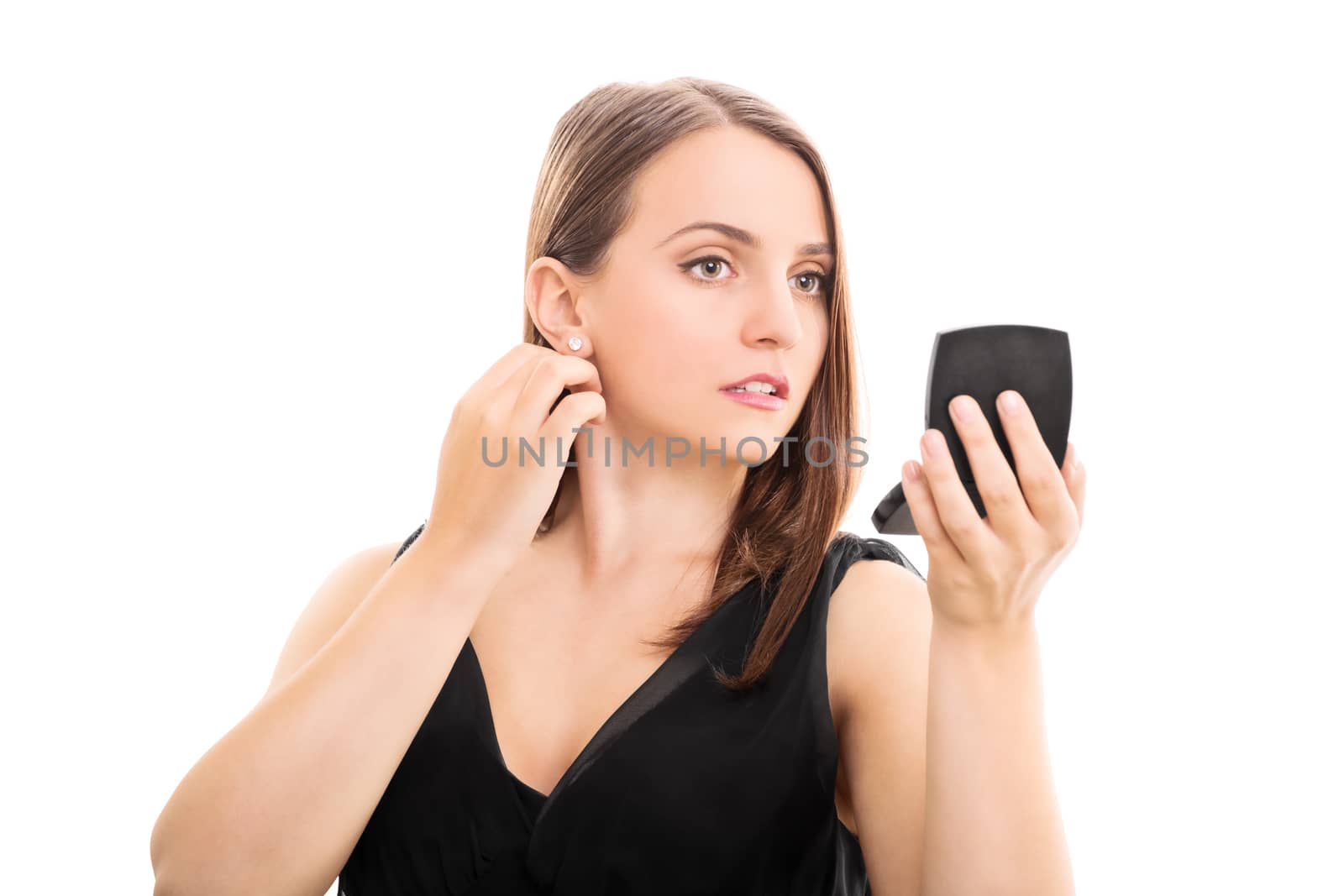 Beautiful elegant young woman looking in a makeup mirror, isolated on white background. Young woman preparing for a date.