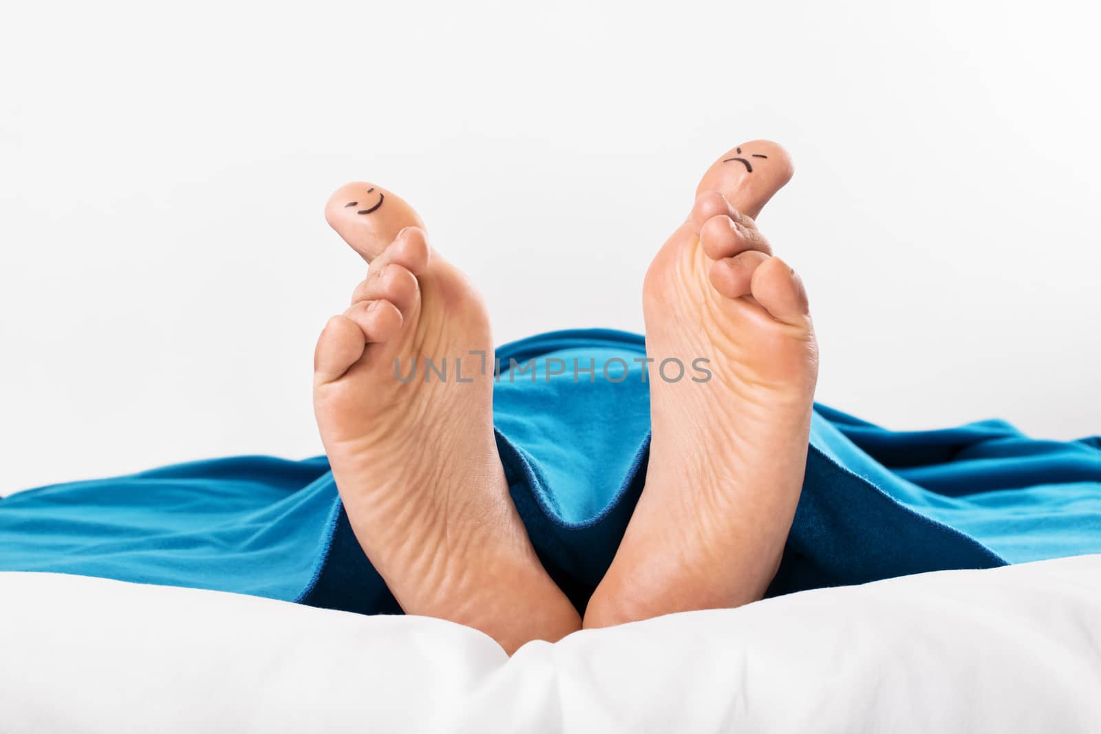 Human feet with smiley and grumpy drawn on them by Mendelex