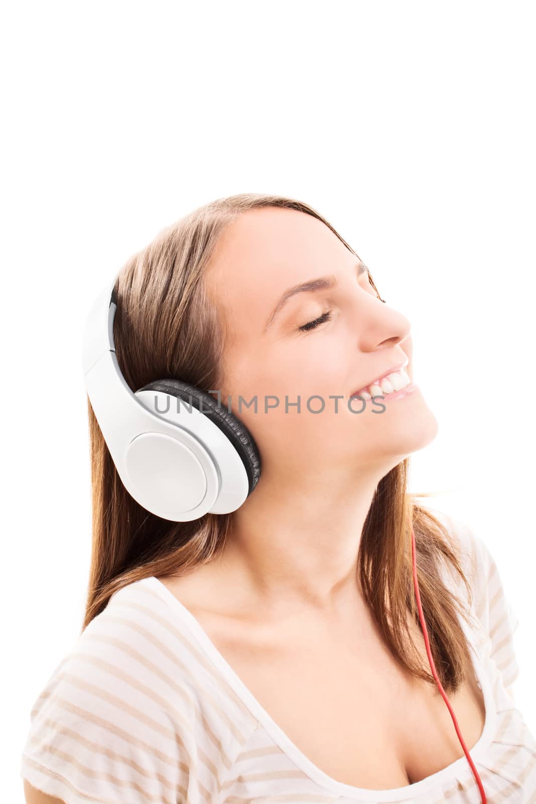 Beautiful young girl with headphones listening to music, isolated on white background.