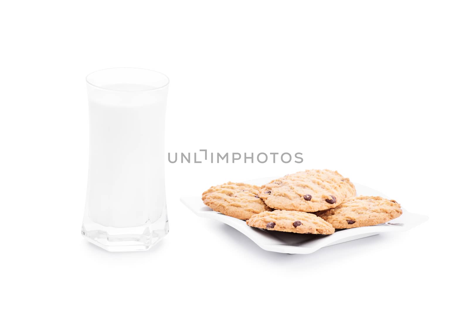 Close up shot of chocolate chip cookies on a platter with a glass of milk, isolated on white background.