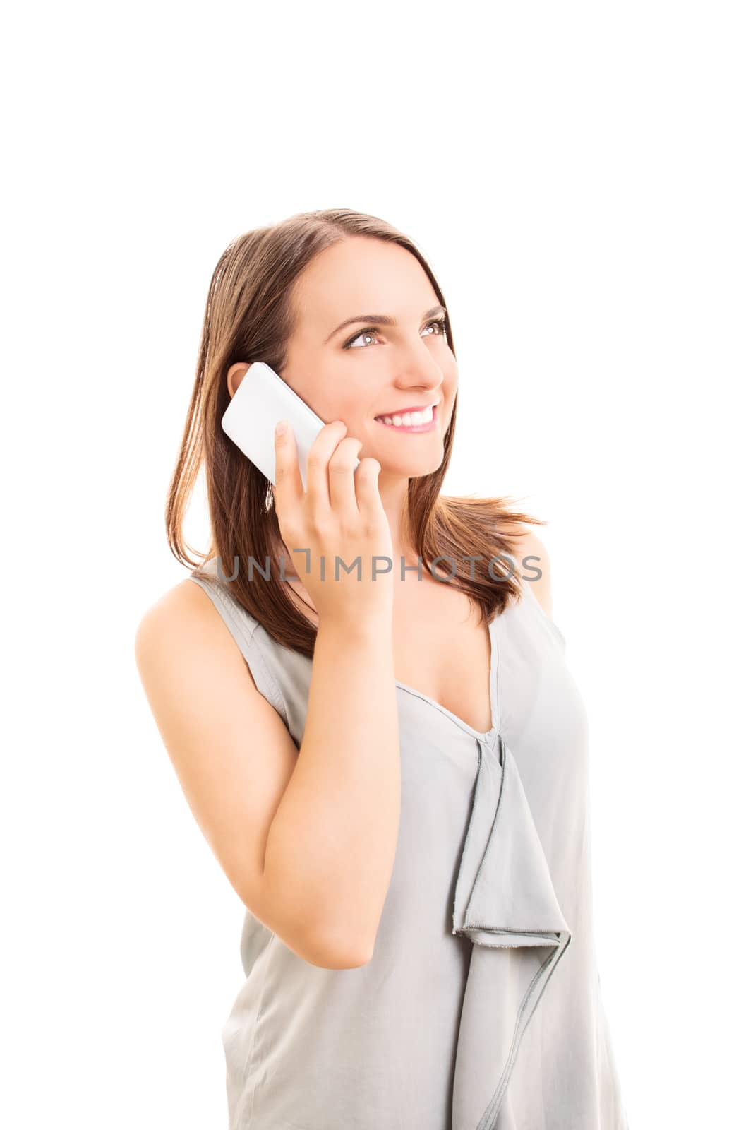 Smiling beautiful young woman talking on a phone, isolated on white background.