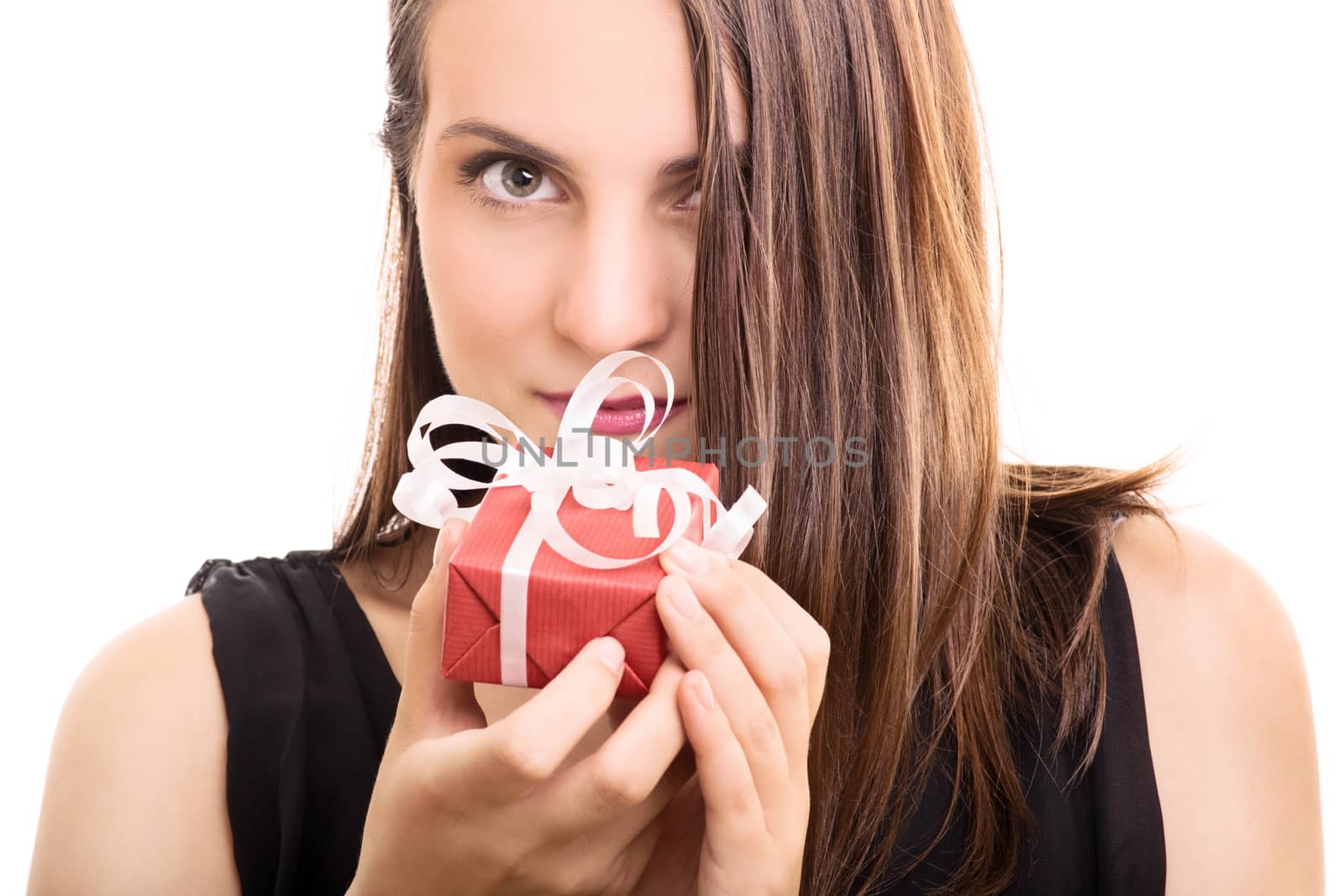 Close-up shot of a beautiful young woman holding a gift, making an impression it's a precious one, isolated on white background.