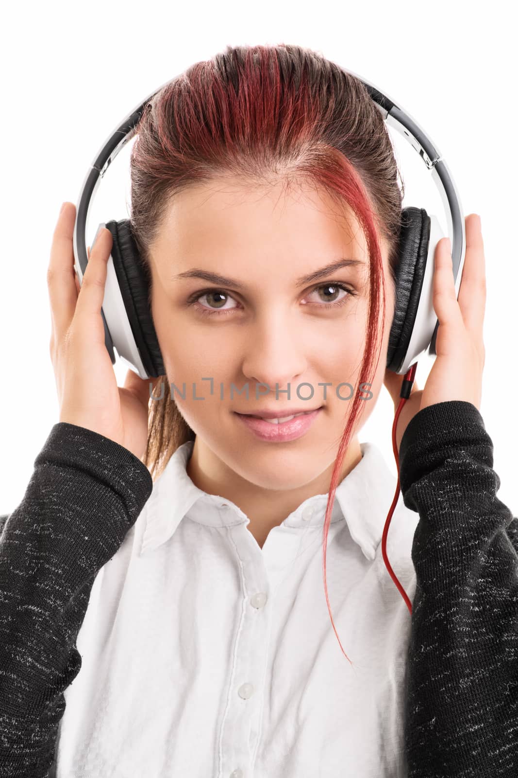 Shh, I am listening to my favorite song. Beautiful young girl with headphones listening to music, isolated on white background.