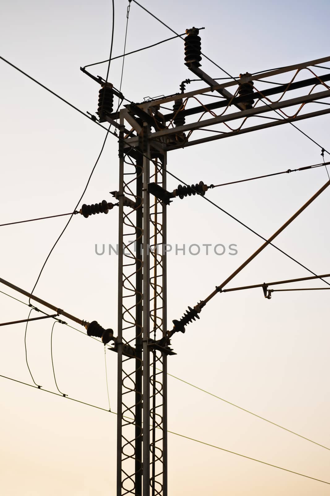 Railroad power transmission line tower during sunset.