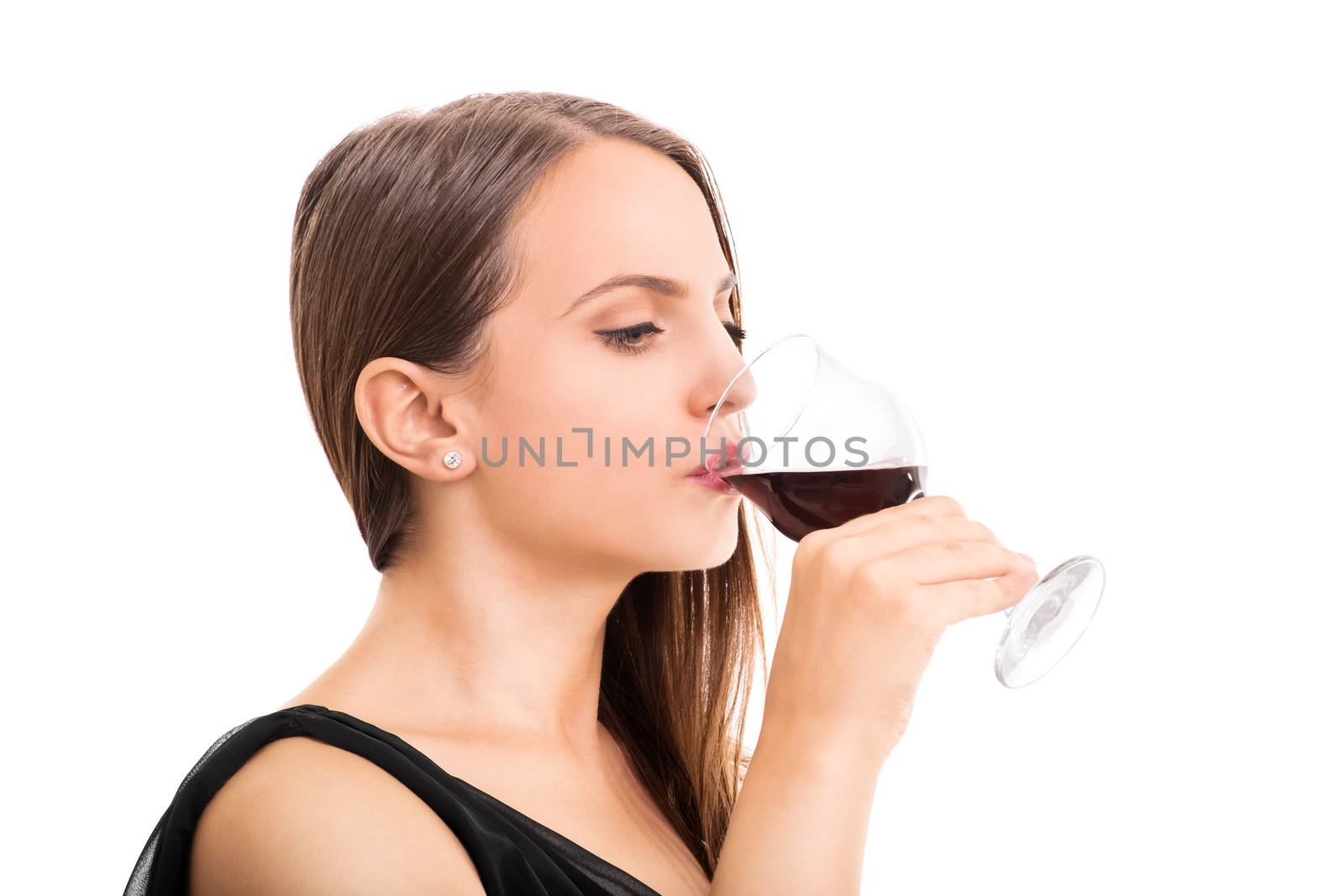 Beautiful young woman taking a sip of a wine glass, isolated on white background.