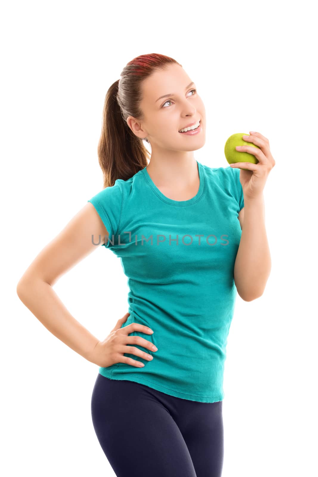 A portrait of a smiling beautiful young girl in fitness clothes holding an apple, isolated on white background.