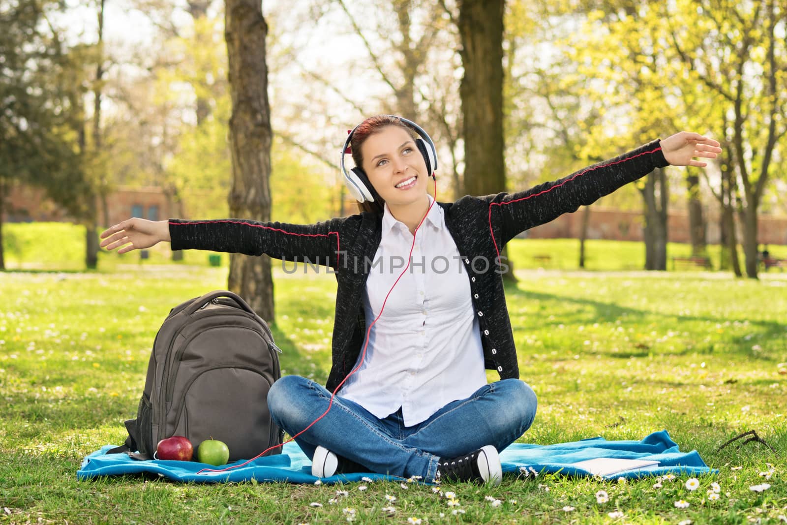 Student in a park with arms outstretched as if she's flying by Mendelex