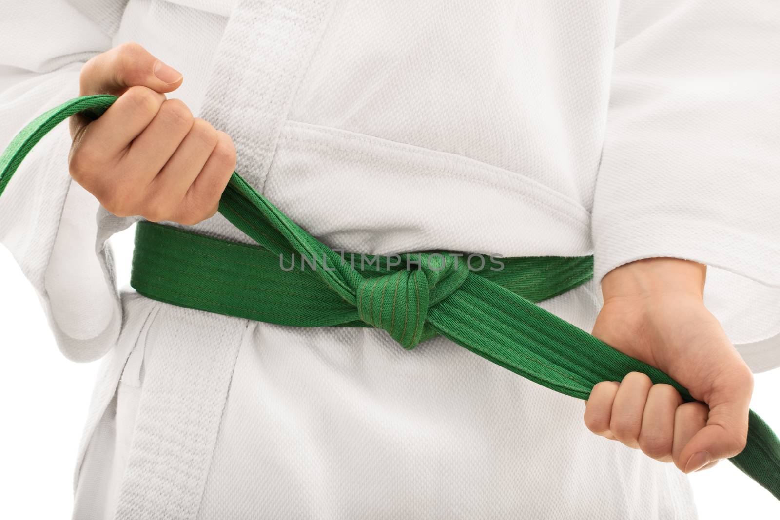 Tying a kimono belt. Close up shot of the mid section of a girl in kimono, tying her green belt, isolated on white background.