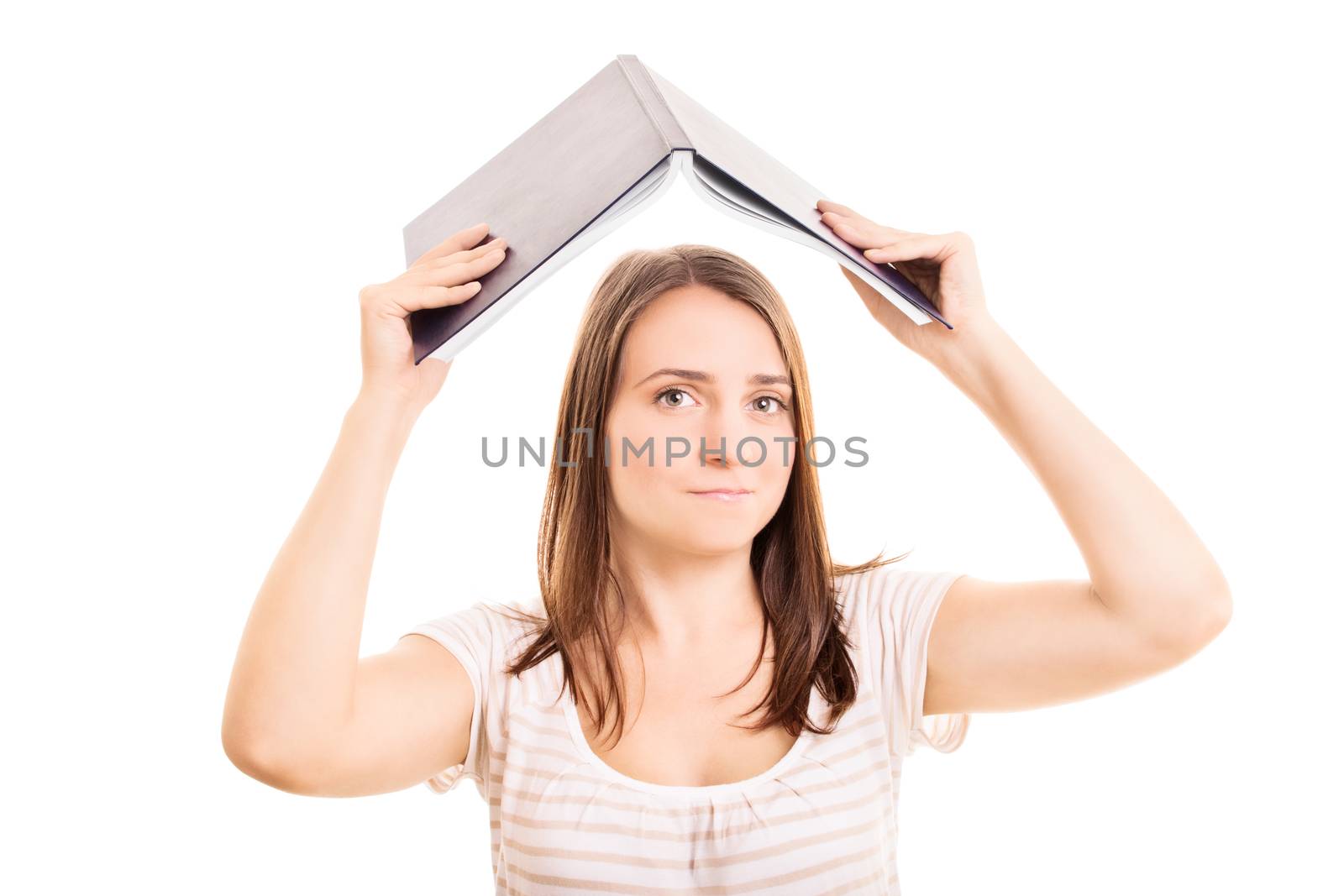 Young girl holding an open book on top of her head, looking worried, isolated on white background.