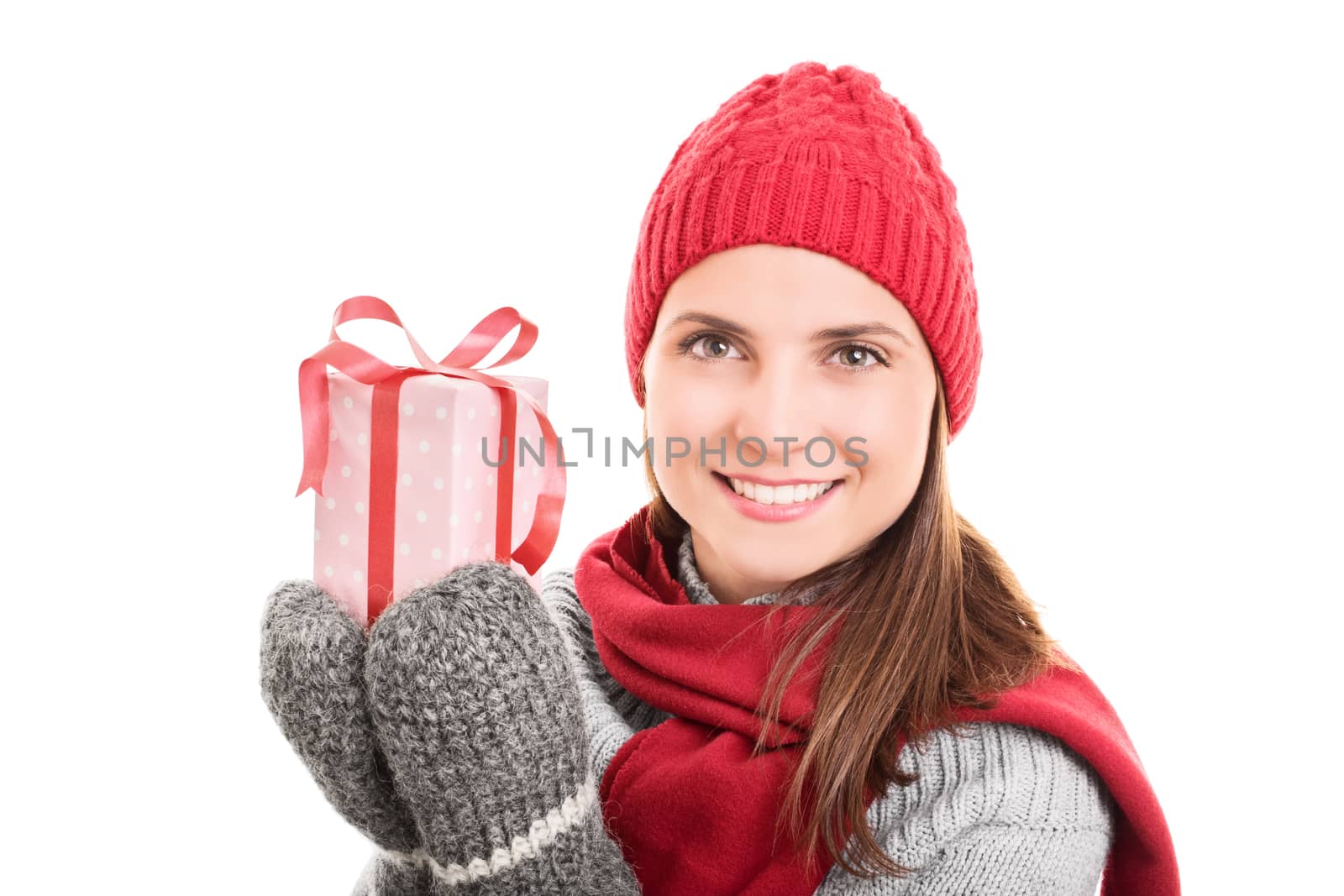 Portrait of a young beautiful woman in winter clothes holding a wrapped present, isolated on white background.