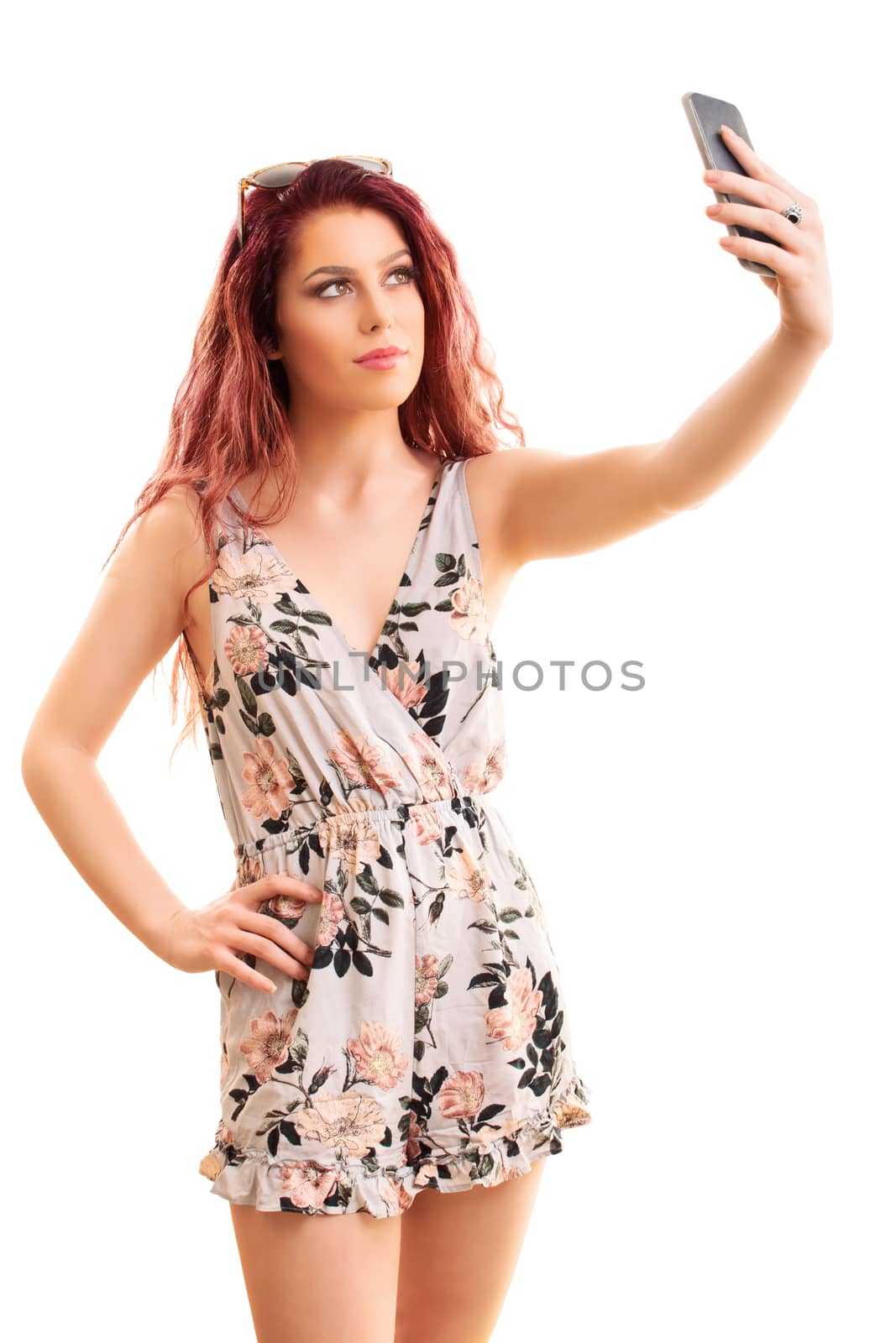 Beautiful smiling fashionable young girl taking a selfie, isolated on a white background.

