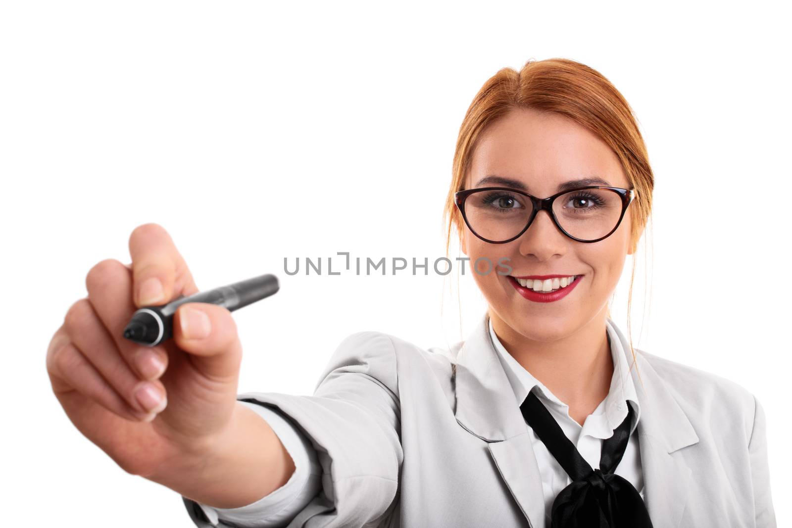 Smiling beautiful young business woman pointing at a virtual point with a pen, isolated on a white background.