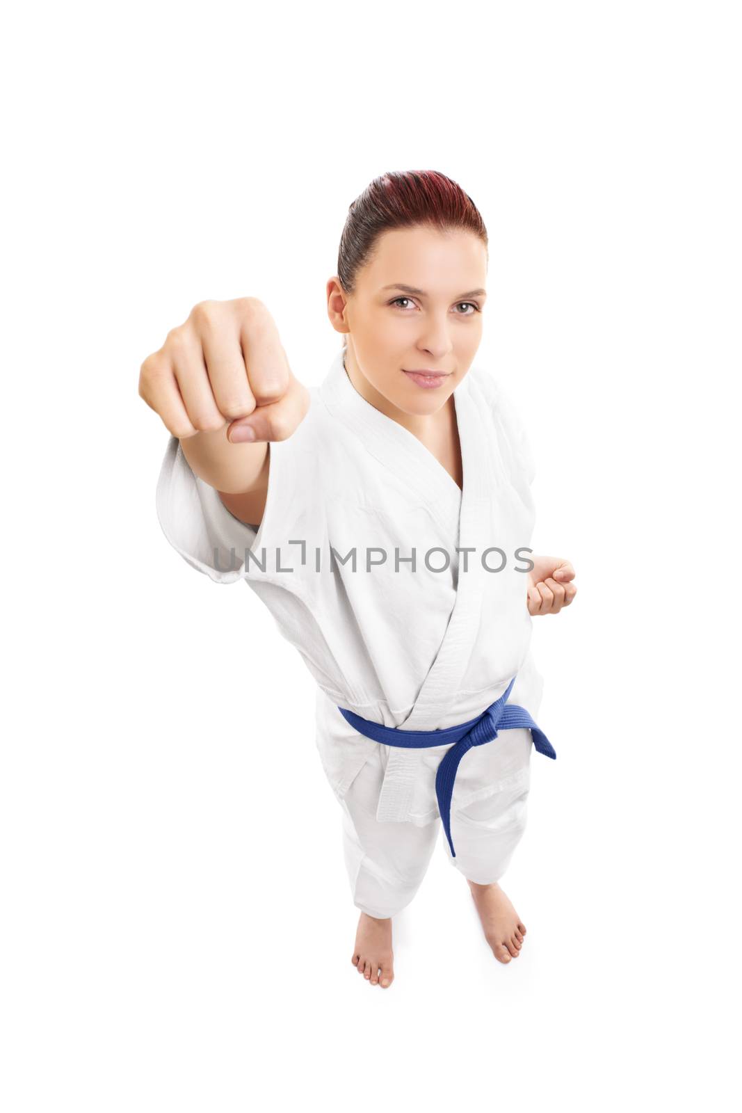 A portrait of a beautiful young female aikido fighter attacking, from top, isolated on white background.