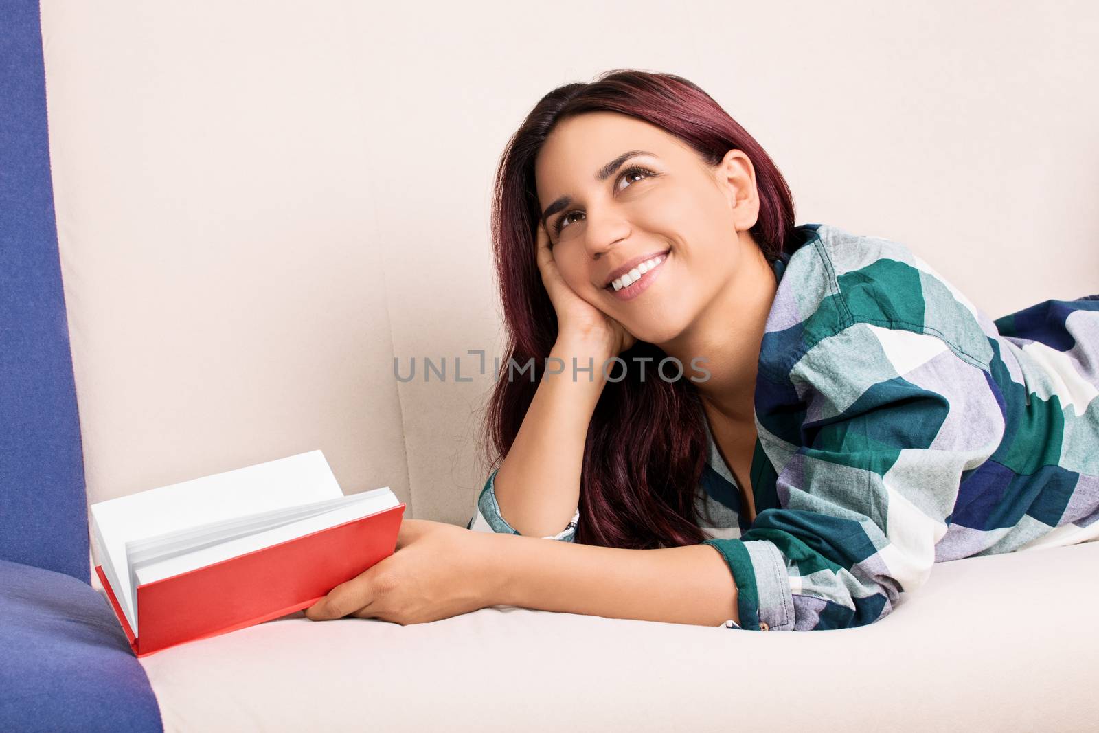 Young girl daydreaming while reading a book by Mendelex