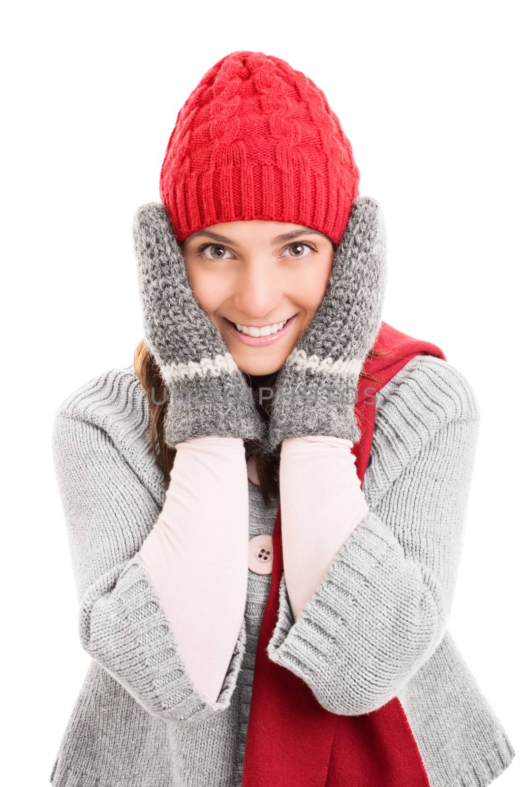 Portrait of a beautiful smiling young woman with warm winter clothes holding her cheeks, isolated on white background.