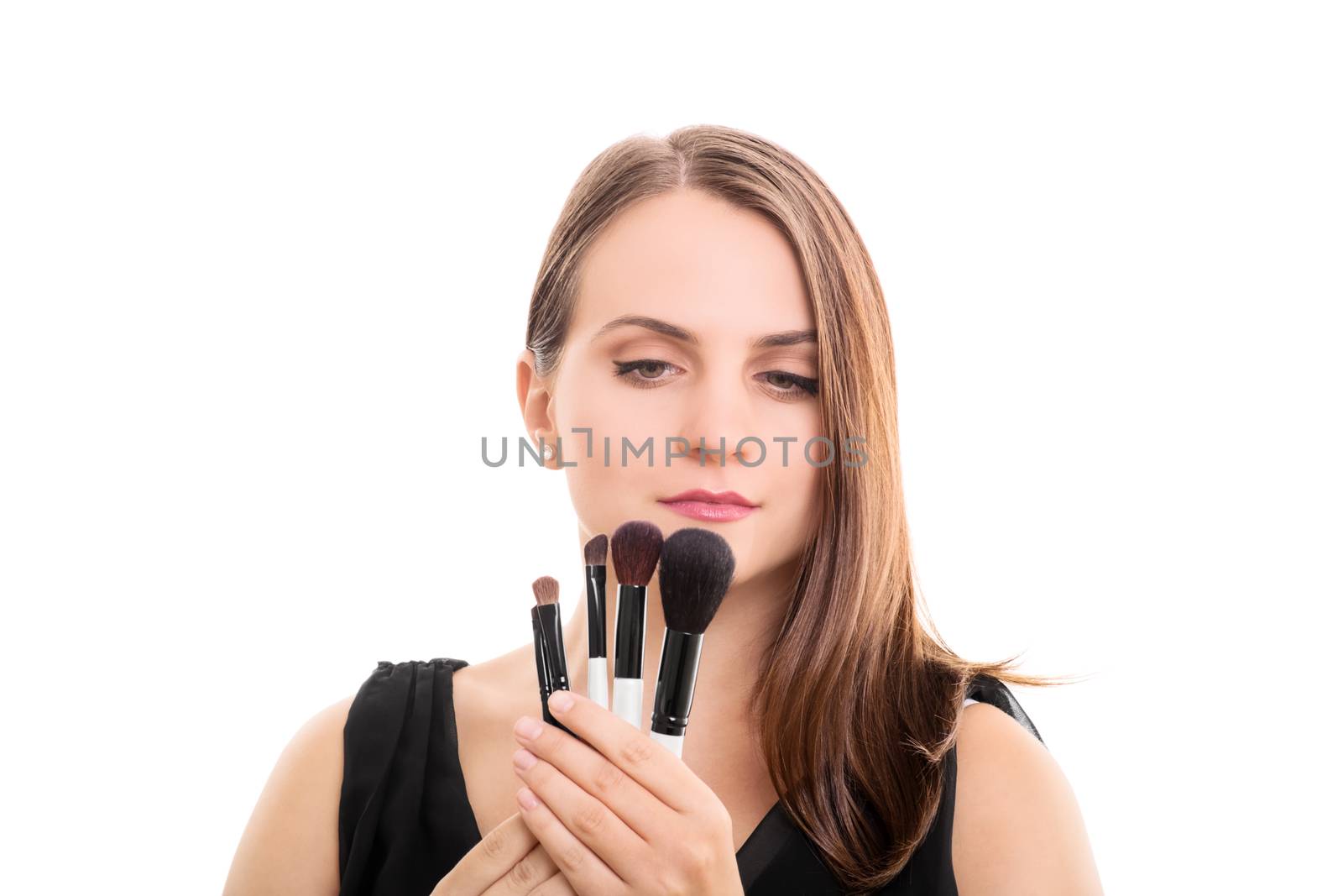 Beautiful young girl holding make up brushes, isolated on white background.