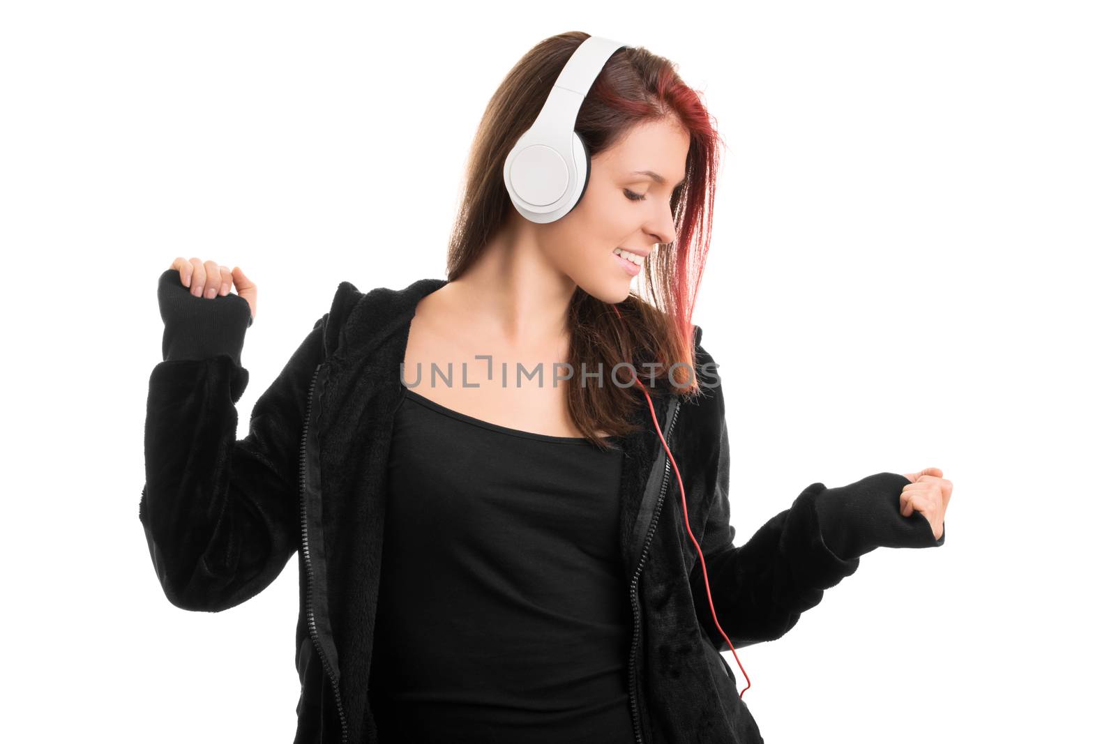 Dancing my song away. Young girl in a hoodie with headphones, isolated on white background.