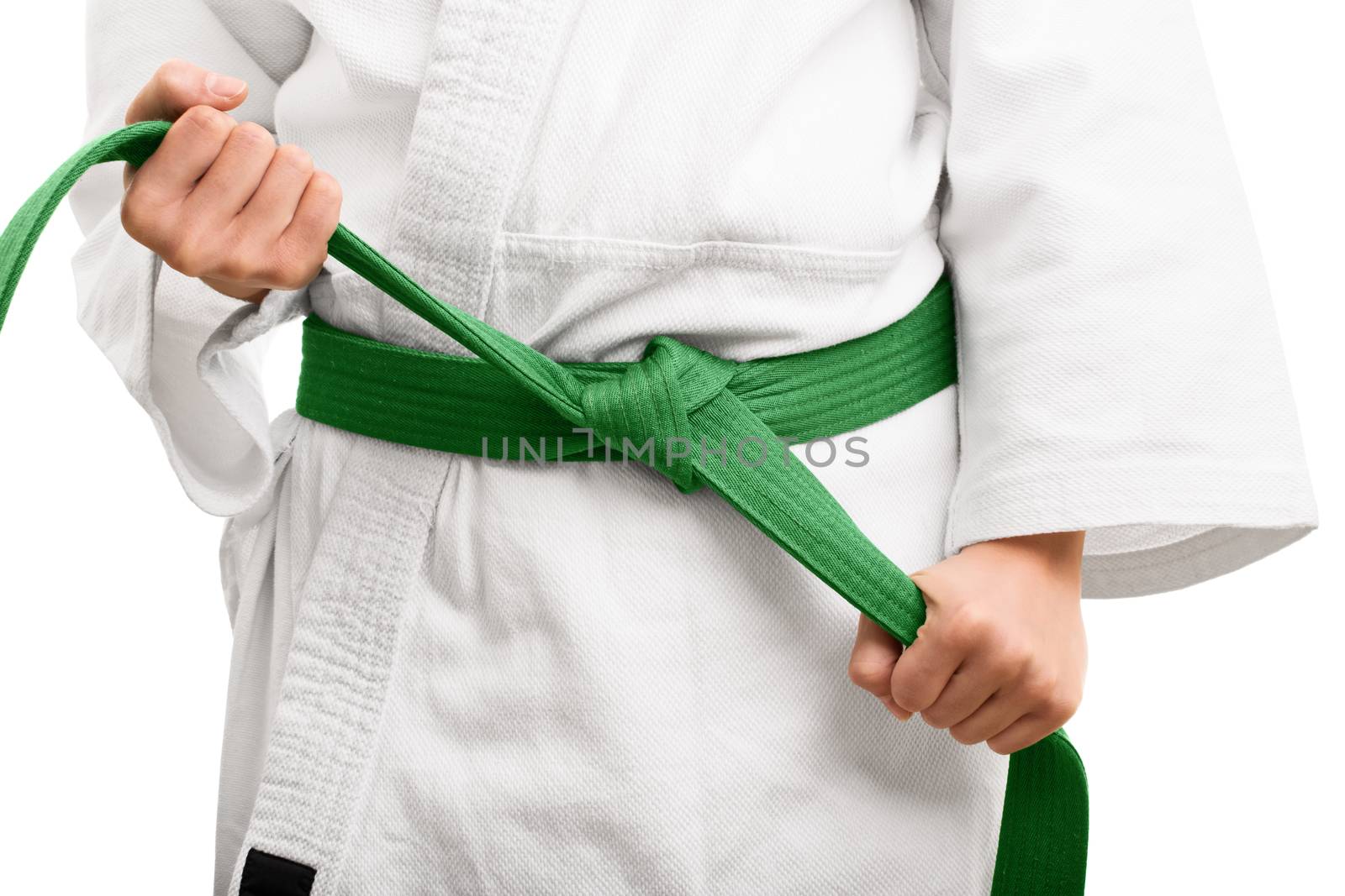 Close up shot of the mid section of a girl in kimono, tying her green belt, isolated on white background.