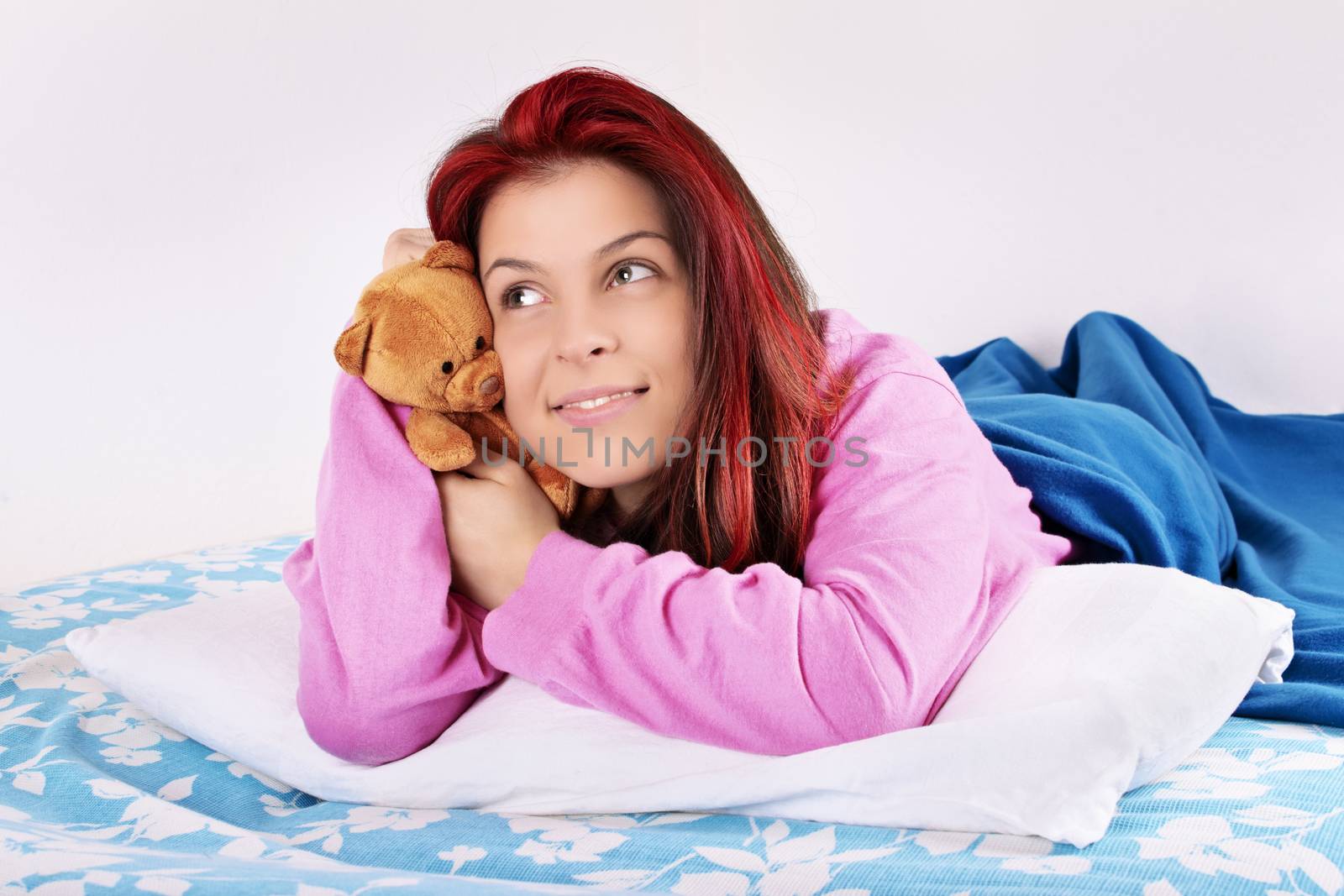 Young girl in bed hugging her plush friend by Mendelex