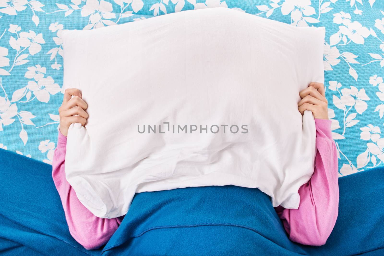 Young girl in bed with a pillow on top of her head by Mendelex