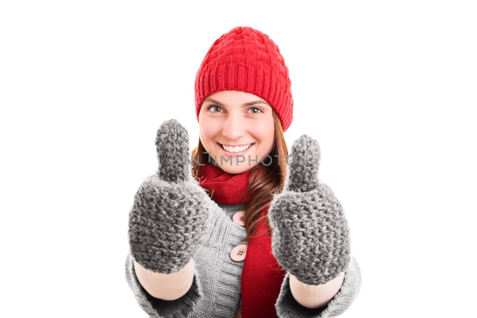 A portrait of a beautiful smiling young girl in winter clothes giving a thumbs up, isolated on white background.