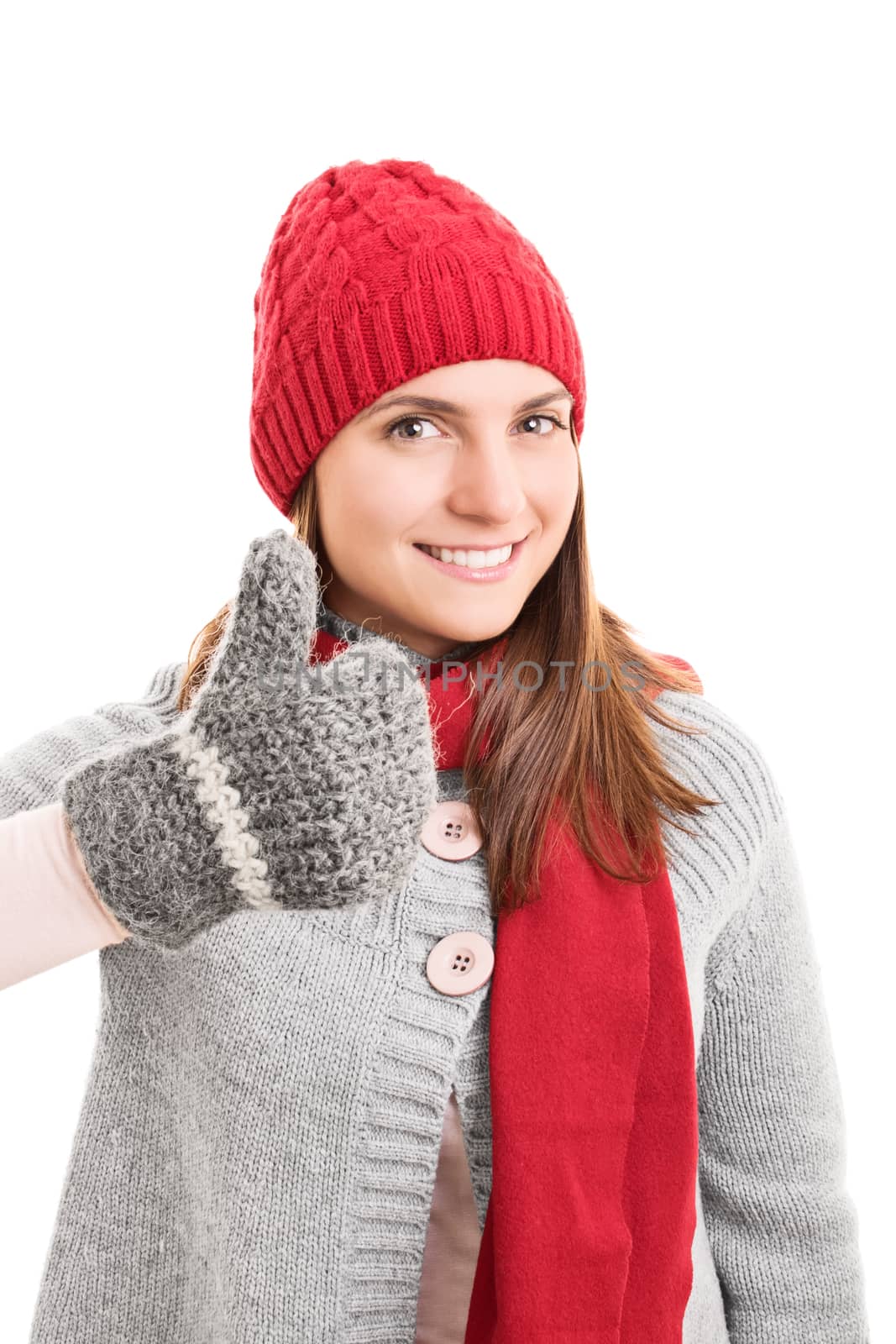 Beautiful smiling young girl in winter clothes holding thumbs up, isolated on white background.