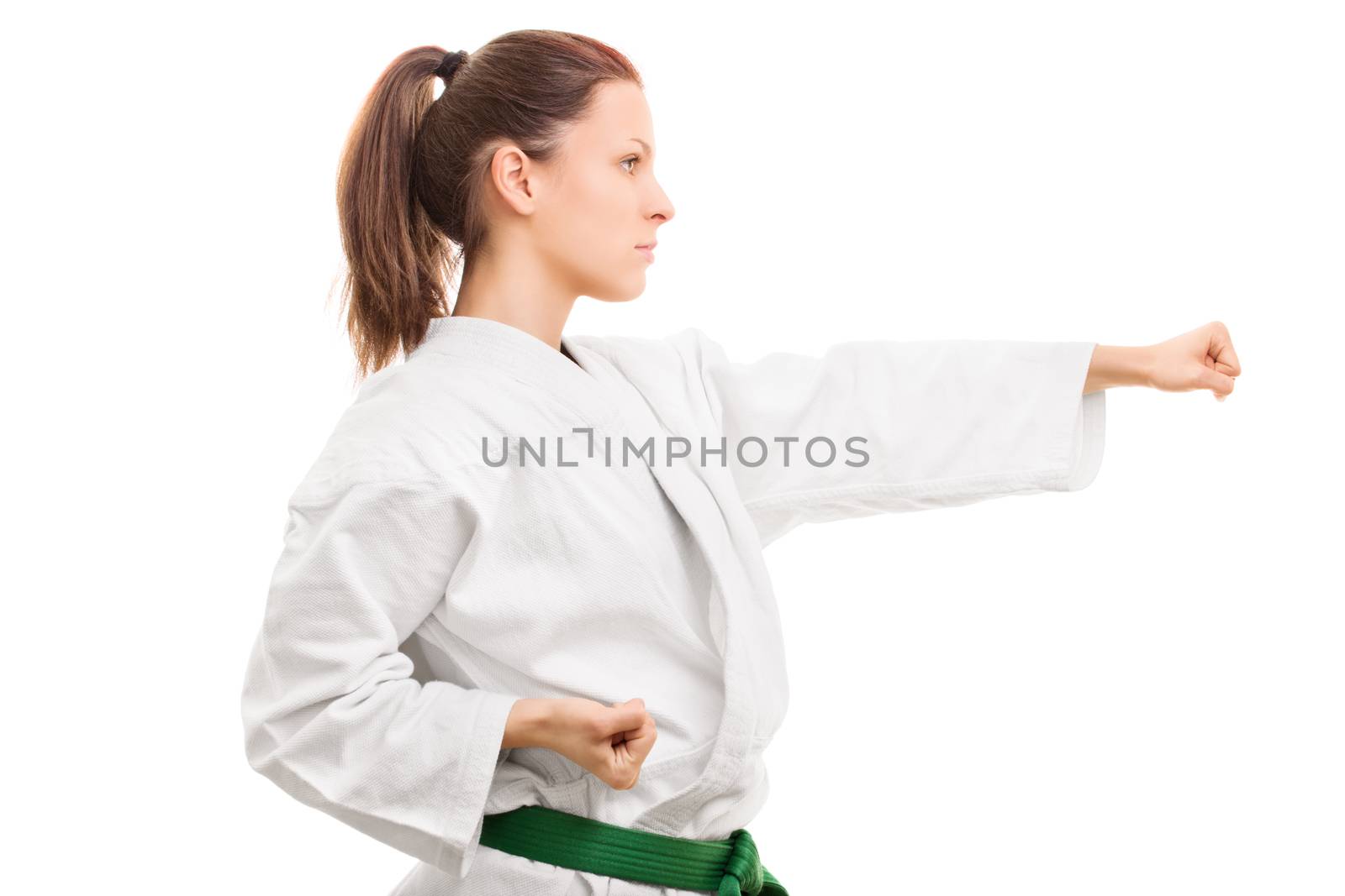 Sports and practice. Side view of a beautiful young girl in kimono, standing in a stance, isolated on white background.